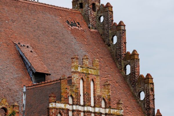 A red brick church roof with unique architecture.