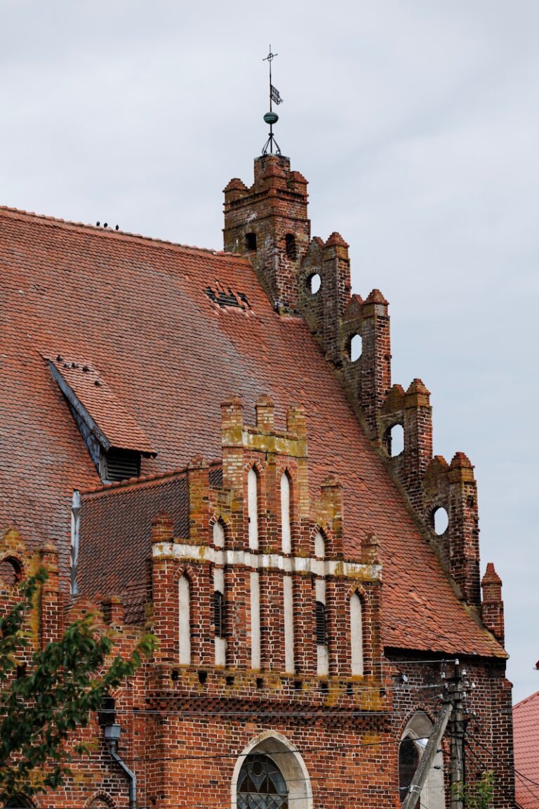 A red brick church roof with unique architecture.